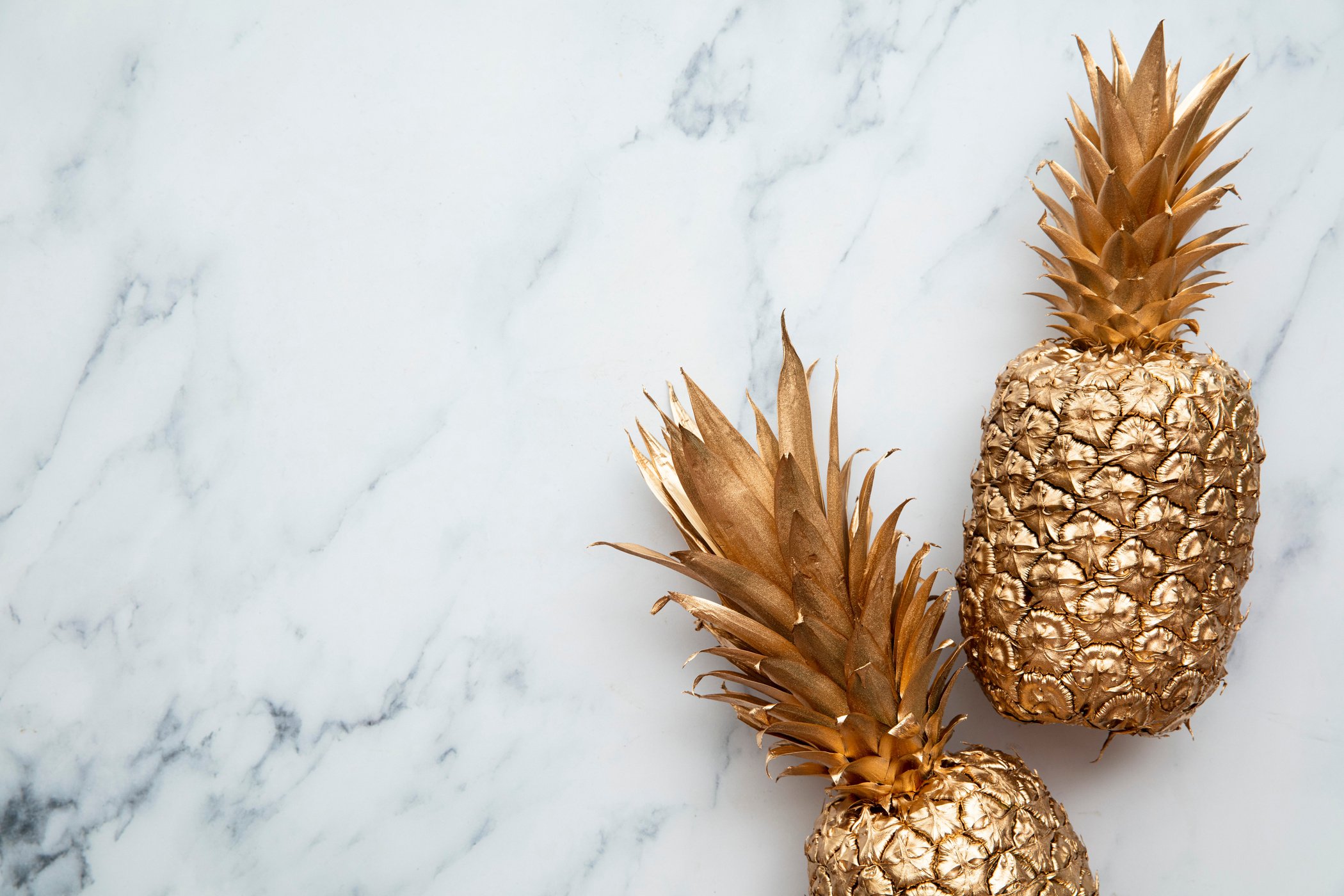 Golden Pineapples on Marble Background Copy Space